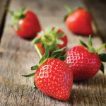 Organic strawberries on a wooden board. Strawberries are an example of foods high in vitamin C and antioxidants.