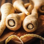 A pile of parsnips on a table. This paprika parsnip fries recipe is loaded with antioxidants and other healthy nutrients.