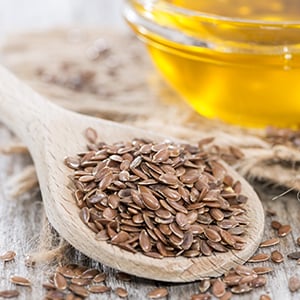 A Wooden spoon filled with flaxseeds. Flaxseed oil has been found to be beneficial for those who suffer from high cholesterol.