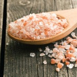 Himalayan Salt on a wooden spoon. The Himalayan Salt Inhaler has many benefits of salt-air therapy and other health benefits.