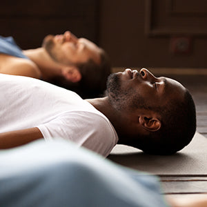 People on floor in deep meditation.