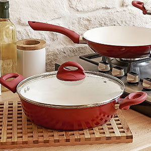 A counter with several pieces of cookware.