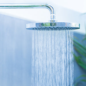 A shower head with running water.