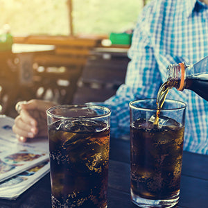 A person pouring diet soda into the glass. Diet drinks have aspartame which is a addicting chemical.