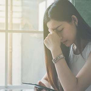 Woman with environmental stressors contemplating how it’s affecting her health.