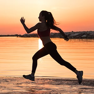 A woman is running on the beach. Exercising and having a healthy diet can help the female libido and your overall wellness.