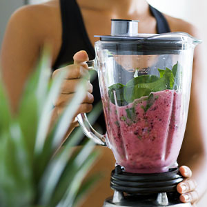 A woman making a healthy smoothie.