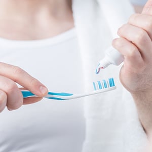 A person holding toothpaste. Fluoride harms the pineal gland health.