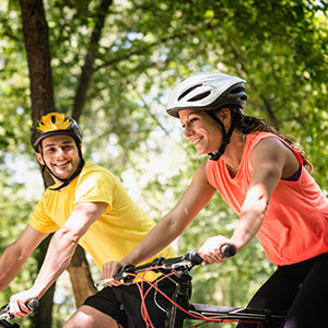 A couple on bike in green scenery.