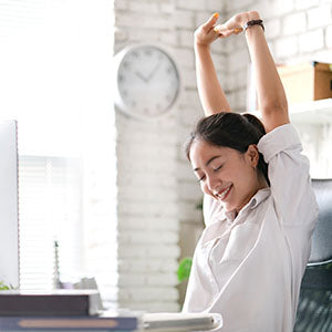 A woman stretching to protect her spine at work.