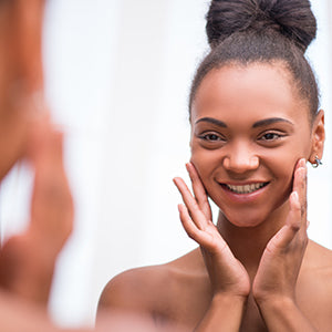 A woman looking at her skin.