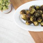 A plate of organic roasted brussels sprouts. This vegan recipe provides plenty of nutrients such as Vitamin C and Vitamin K.