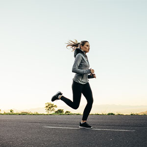 A woman running on a paved track.