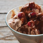 A small bowl of banana cherry chocolate chunk vegan ice cream. This delicious ice cream is packed with healthy nutrients.