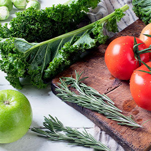 A board of fresh tomatoes, kale, celery, herbs, and more.