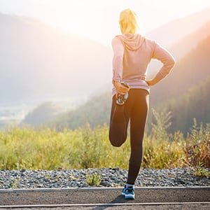 A woman stretching after exercising. Incorporating weight loss supplements with a healthy diet and exercise routine is key to losing weight.