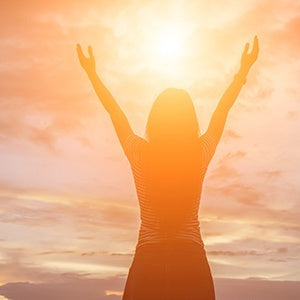 A woman staring at the sun. Understanding what fasting is and the different types can be very beneficial for your health.