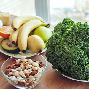 A plate of fruits, nuts, and vegetables.