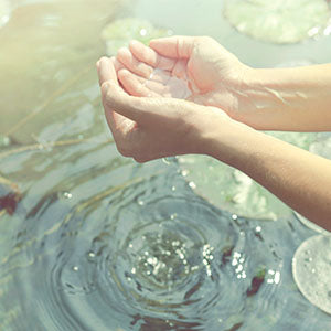 A person holding water in their hands.